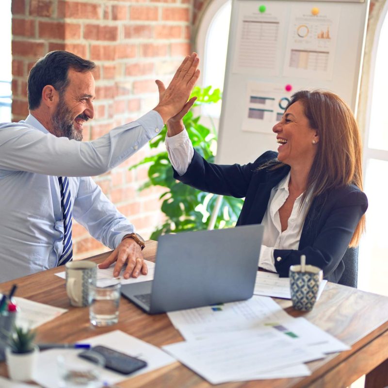 Two colleagues celebrating at a desk
